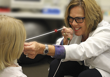 Doctor performing vision therapy on a child.