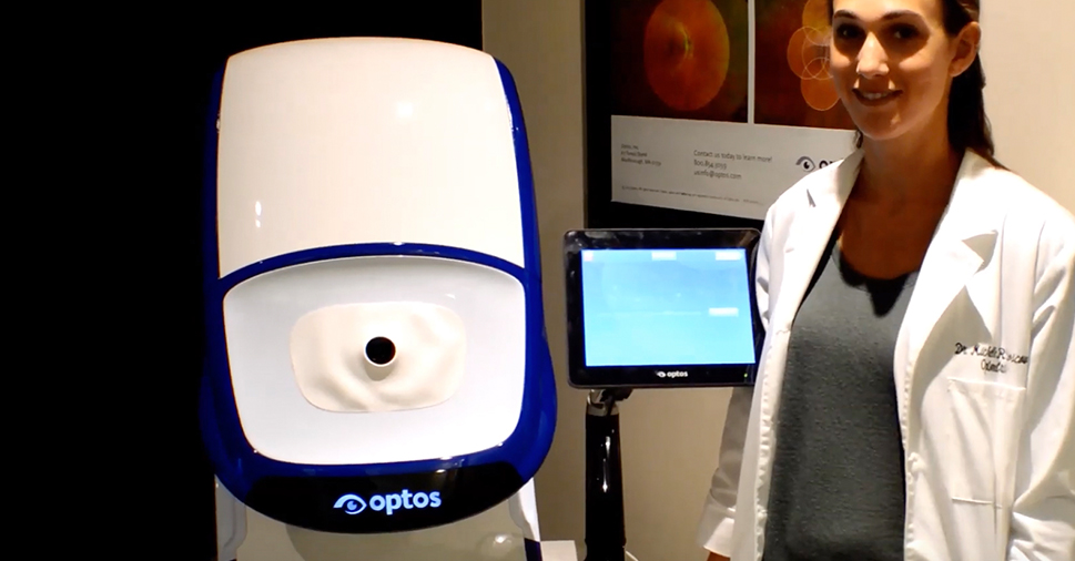 Dr. Michelle Moscow standing by an Optos machine.