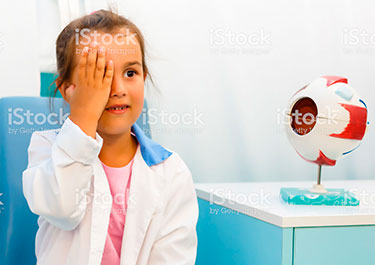 Child covering one eye during eye exam.